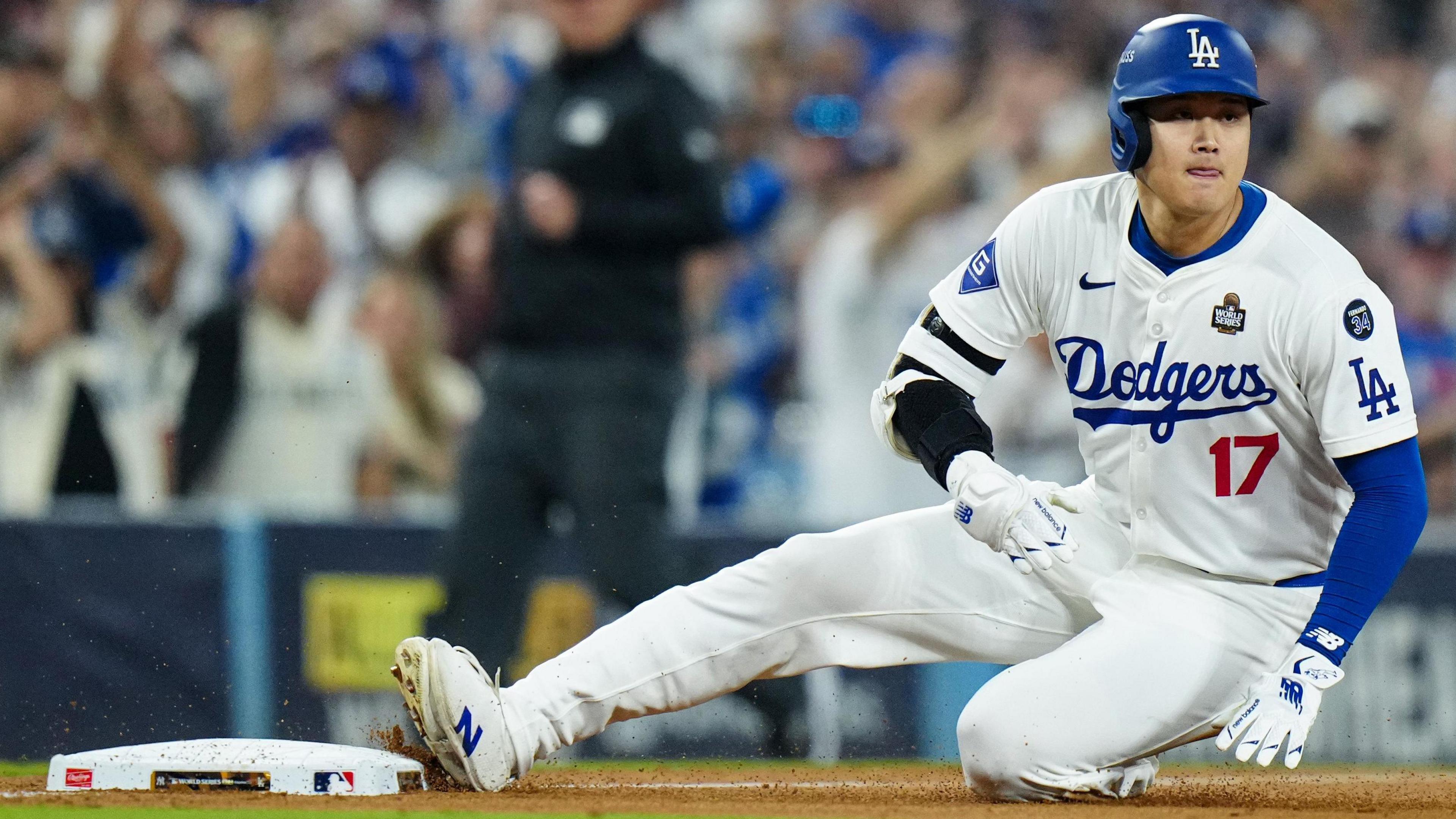 Los Angeles Dodgers designated hitter Shohei Ohtani slides into third base