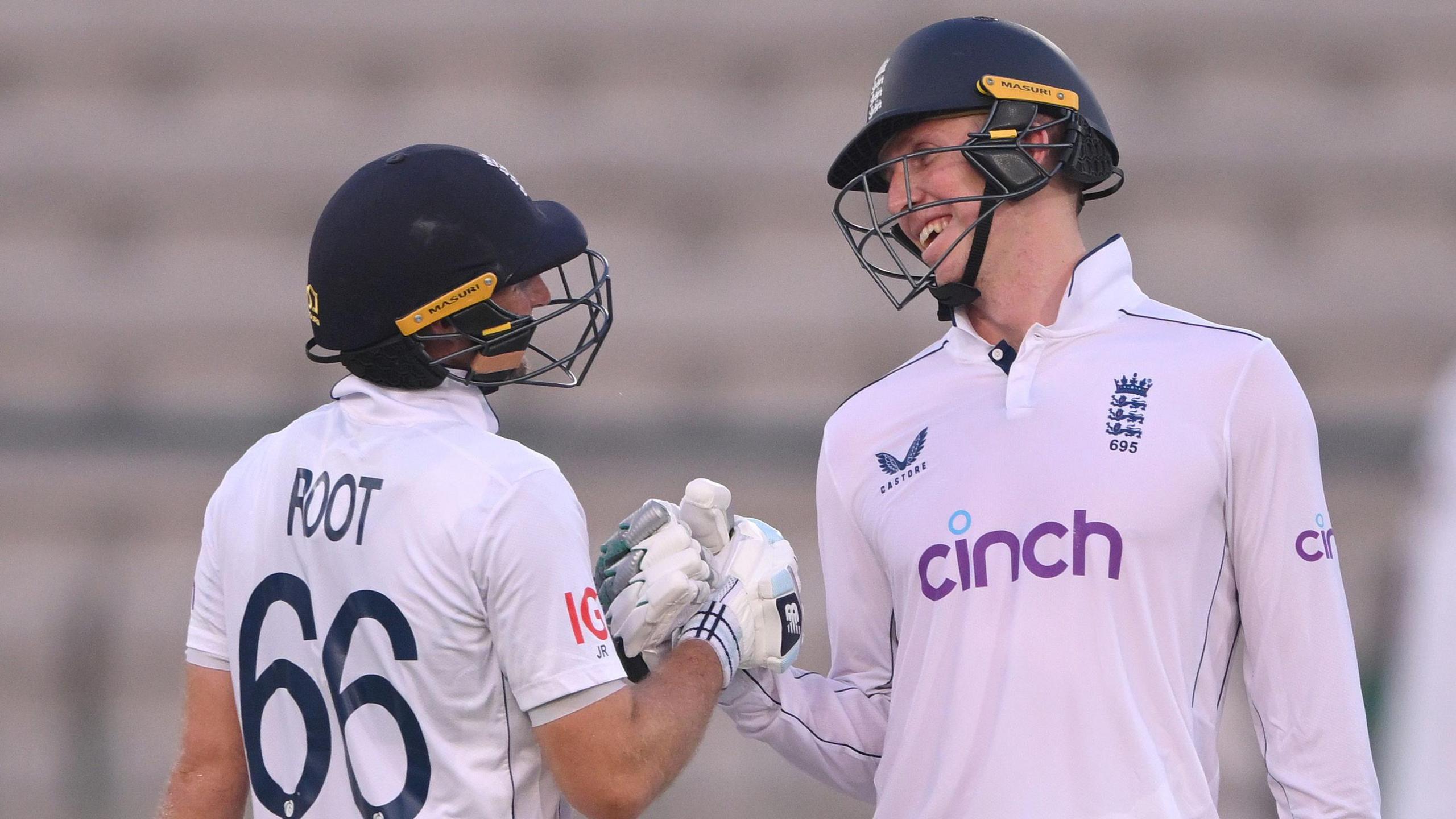 Zak Crawley and Joe Root clench gloves in the first Test against Pakistan