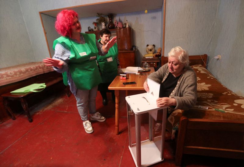 © Reuters. A voter casts a ballot in a portable ballot box brought by electoral officials to her home during parliamentary elections in Tbilisi, Georgia October 26, 2024. REUTERS/Irakli Gedenidze 