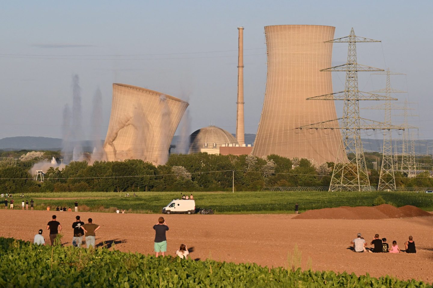 Onlookers watch as the first of the two cooling towers of the nuclear power plant collapses during a controlled demolition in Grafenrheinfeld, Germany on August 16, 2024. The Graferheinfeld nuclear power plant was shut down after a political decision to phase-out nuclear power following the Fukushima nuclear disaster in 2011.