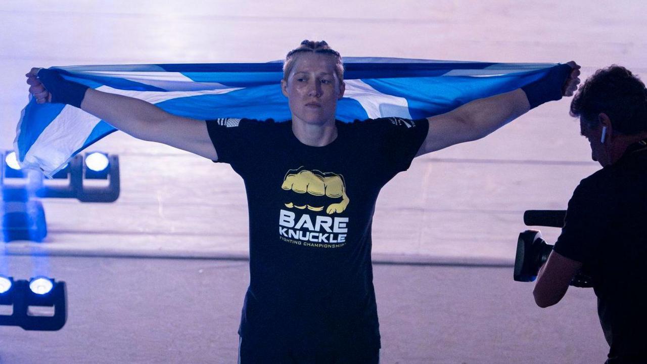 Hannah Rankin poses with a Scotland flag during her BKFC ring walk