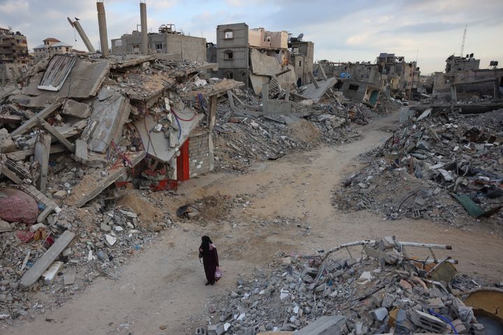 A woman walks past destroyed buildings in Khan Yunis in the southern Gaza Strip on October 17, 2024, amid the ongoing war between Israel and the Palestinian militant group Hamas in the besieged Palestinian territory. (Photo by BASHAR TALEB/AFP via Getty Images)