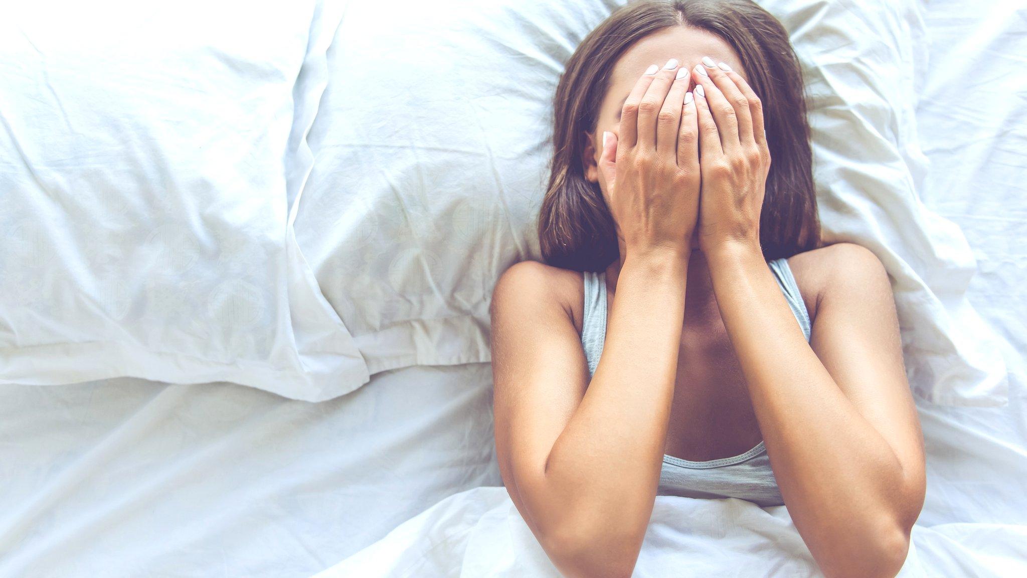 Young woman in bed trying to sleep