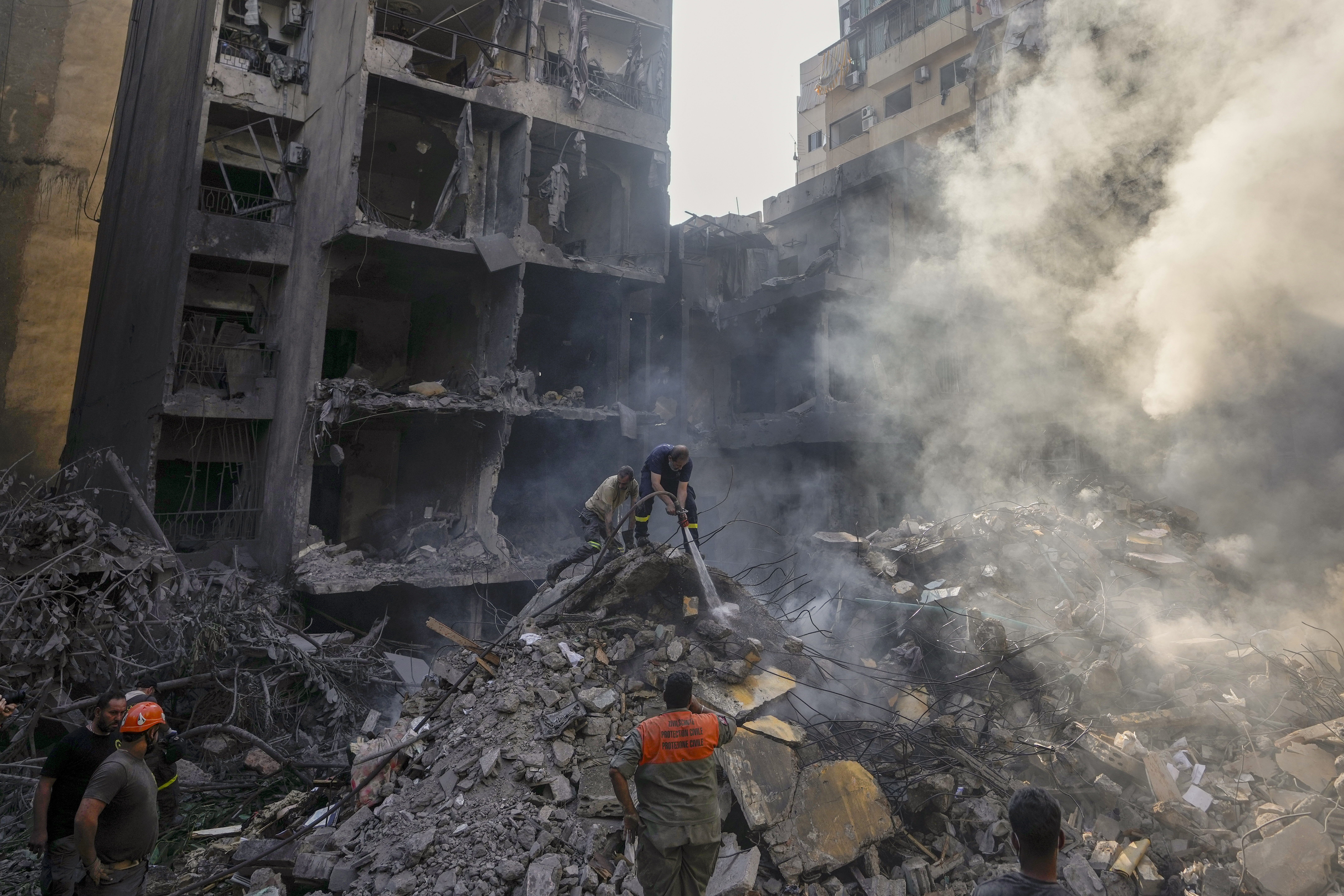 Rescue workers search for victims at the site of Thursday's Israeli airstrike in Beirut, Lebanon, Friday, Oct. 11, 2024. (AP Photo/Hassan Ammar)