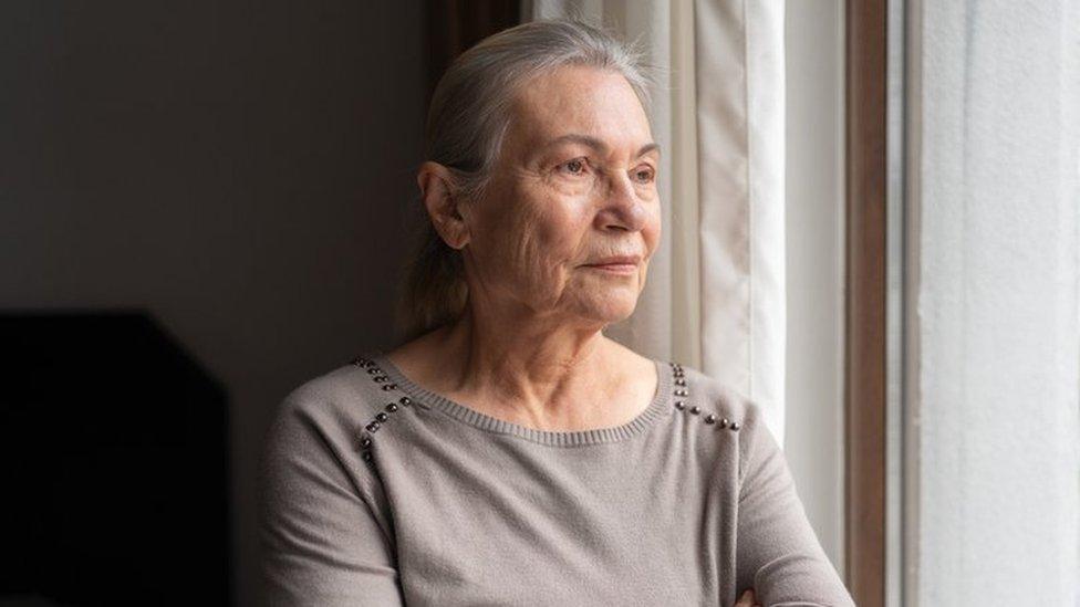 Older woman looking out the window