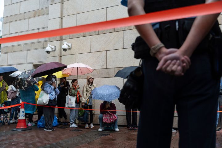 People wait outside the West Kowloon Magistrates' Courts in Hong Kong on Nov. 19, 2024, ahead of the sentencing in national security case.