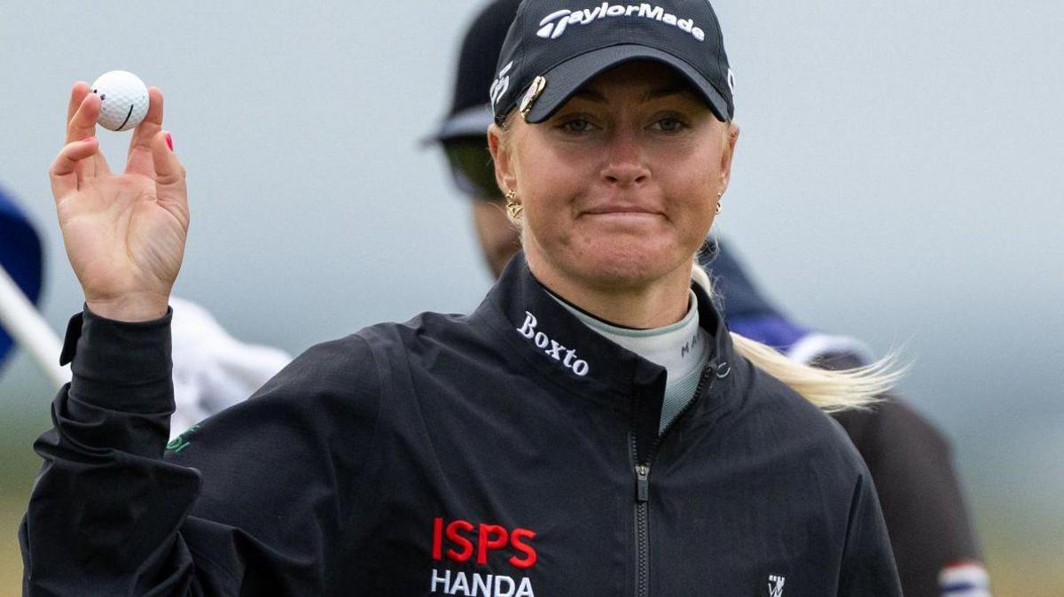 Charley Hull raises her ball aloft while playing at St Andrews