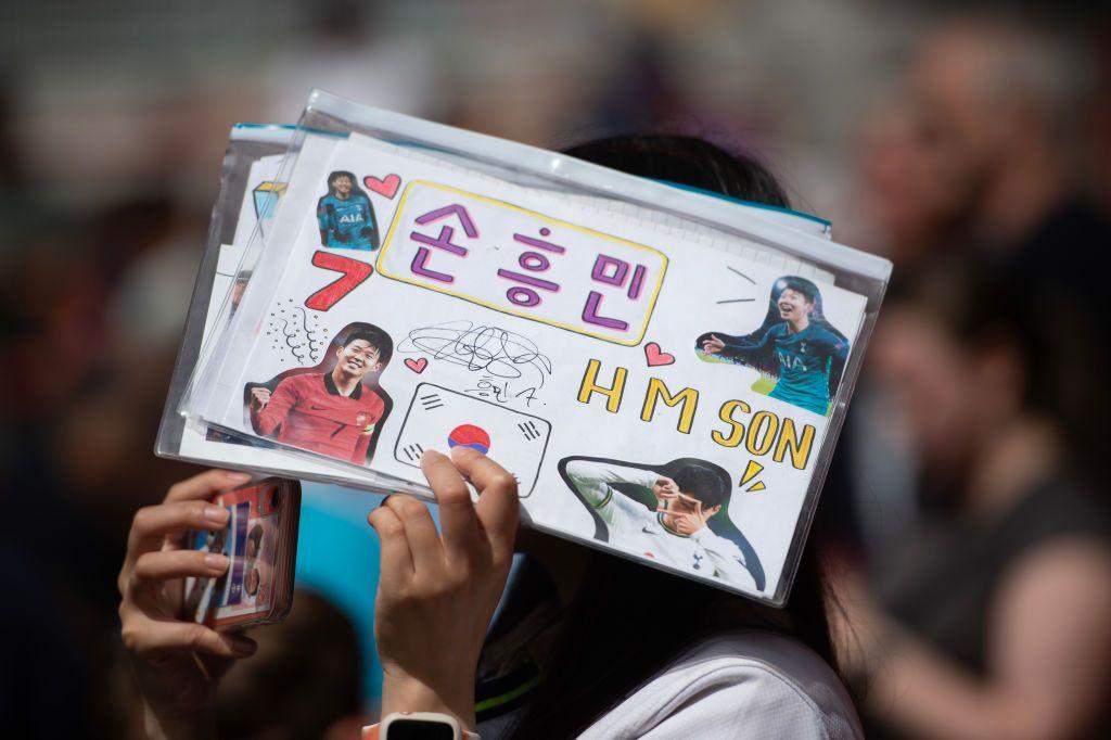 A Tottenham fan holds up a banner supporting Son Heung-min