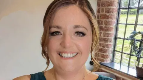 HANDOUT Ellie Lambert wears her hair in a wavy up do and wears pendant earrings as she beams in a selfie while attending an event 