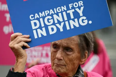 Getty Images A campaigner from "Dignity in Dying" holds a placard during a demonstration outside The Palace of Westminster, home to the Houses of Parliament