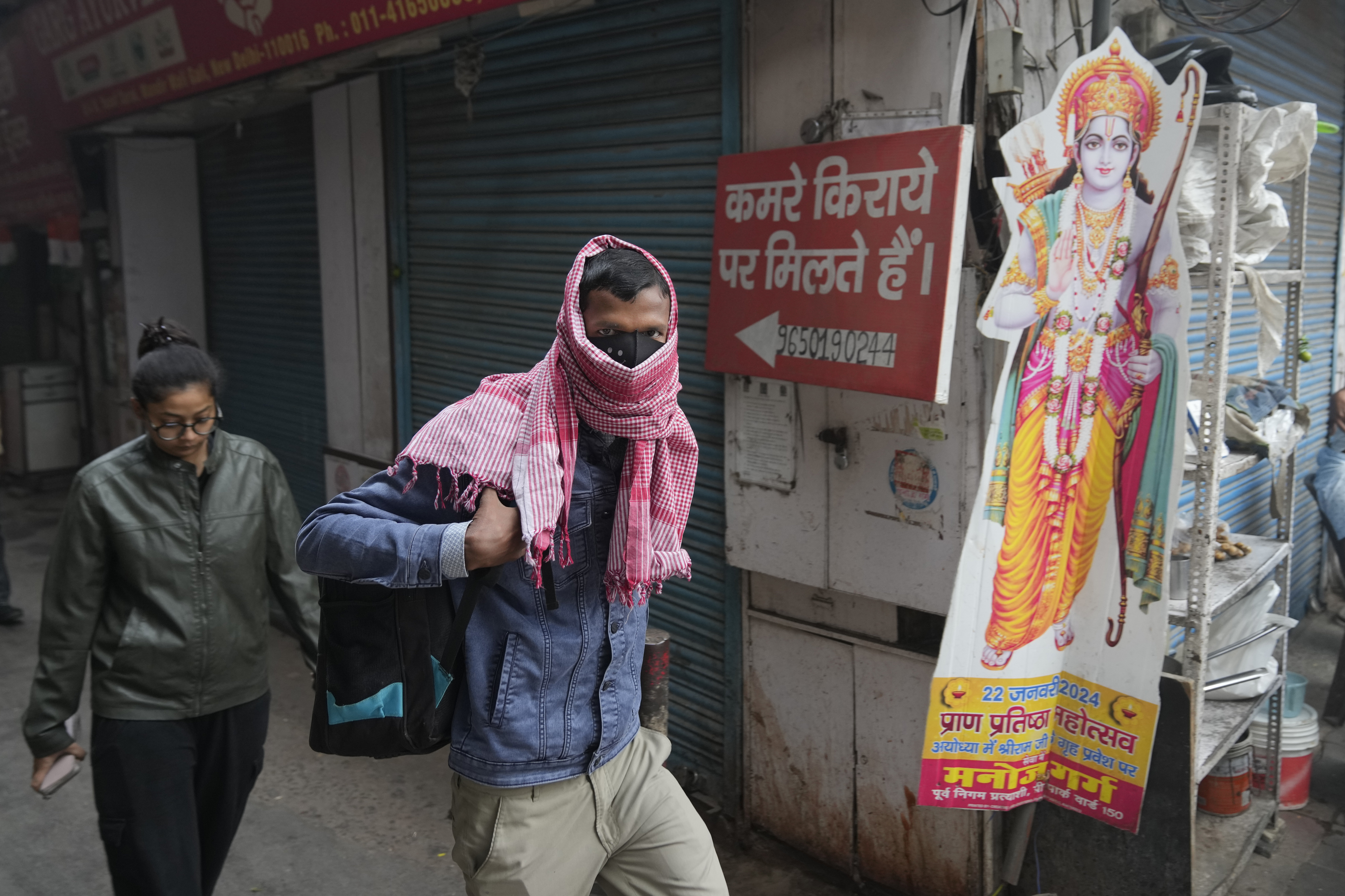 A office goer walks wearing a face mask amidst a thick layer of smog as air pollution shoots up in New Delhi, India, on Nov. 18, 2024.