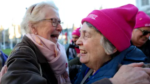 Reuters Two women taking part in a demonstration in support of assisted dying outside Parliament hug after the result of the vote is announced. One is wearing a pink hat reading: Campaign For Dignity In Dying