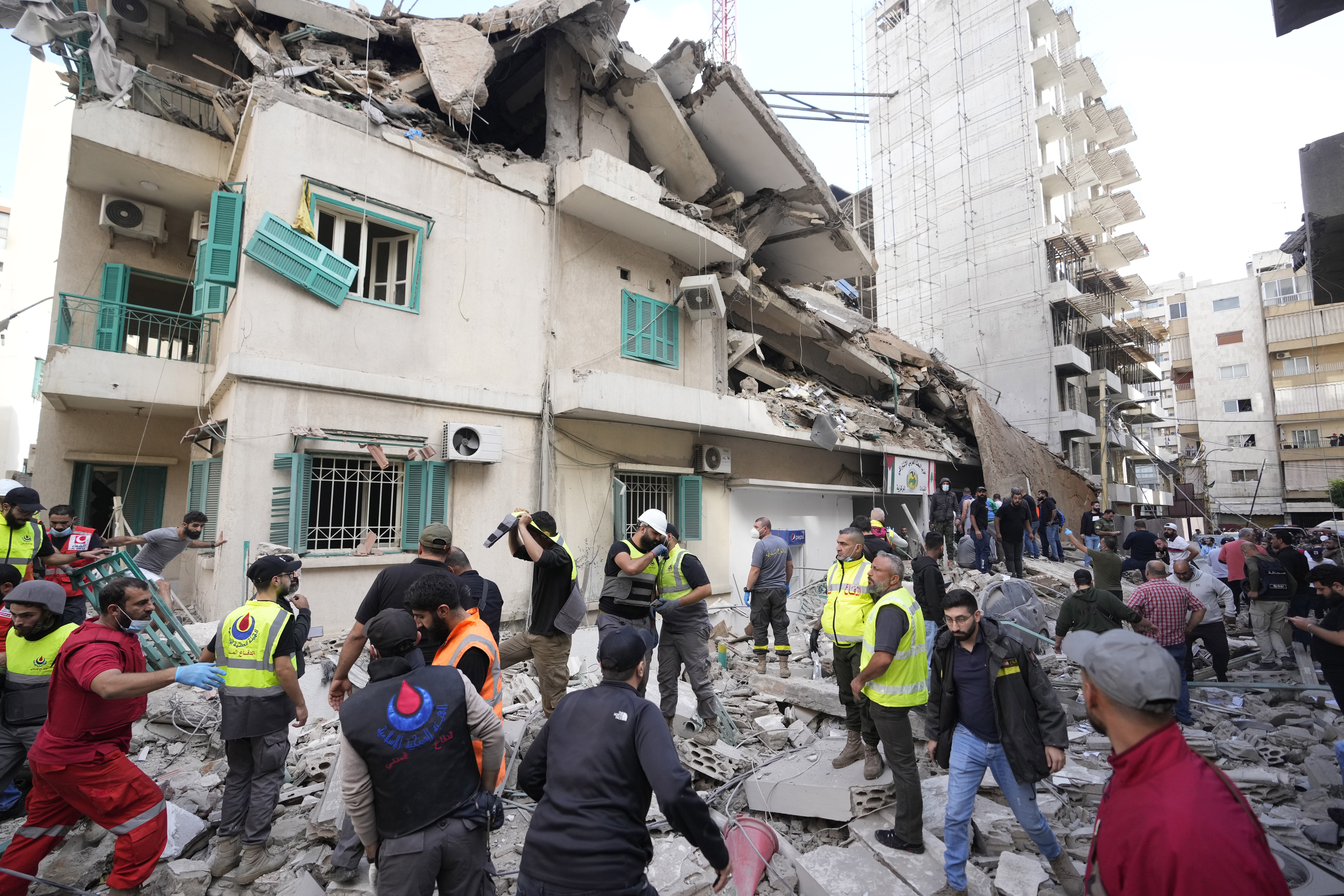 Residents and rescuers gather near a damaged building at the site of an Israeli airstrike in central Beirut's Ras el-Nabaa neighborhood, Lebanon, Sunday, Nov. 17, 2024. (AP Photo/Hassan Ammar)