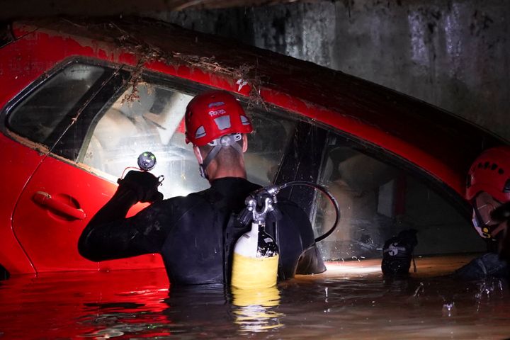 Civil Guards walk in a flooded indoor car park to check cars for bodies after floods in Paiporta, near Valencia, Spain, on Nov. 4, 2024.