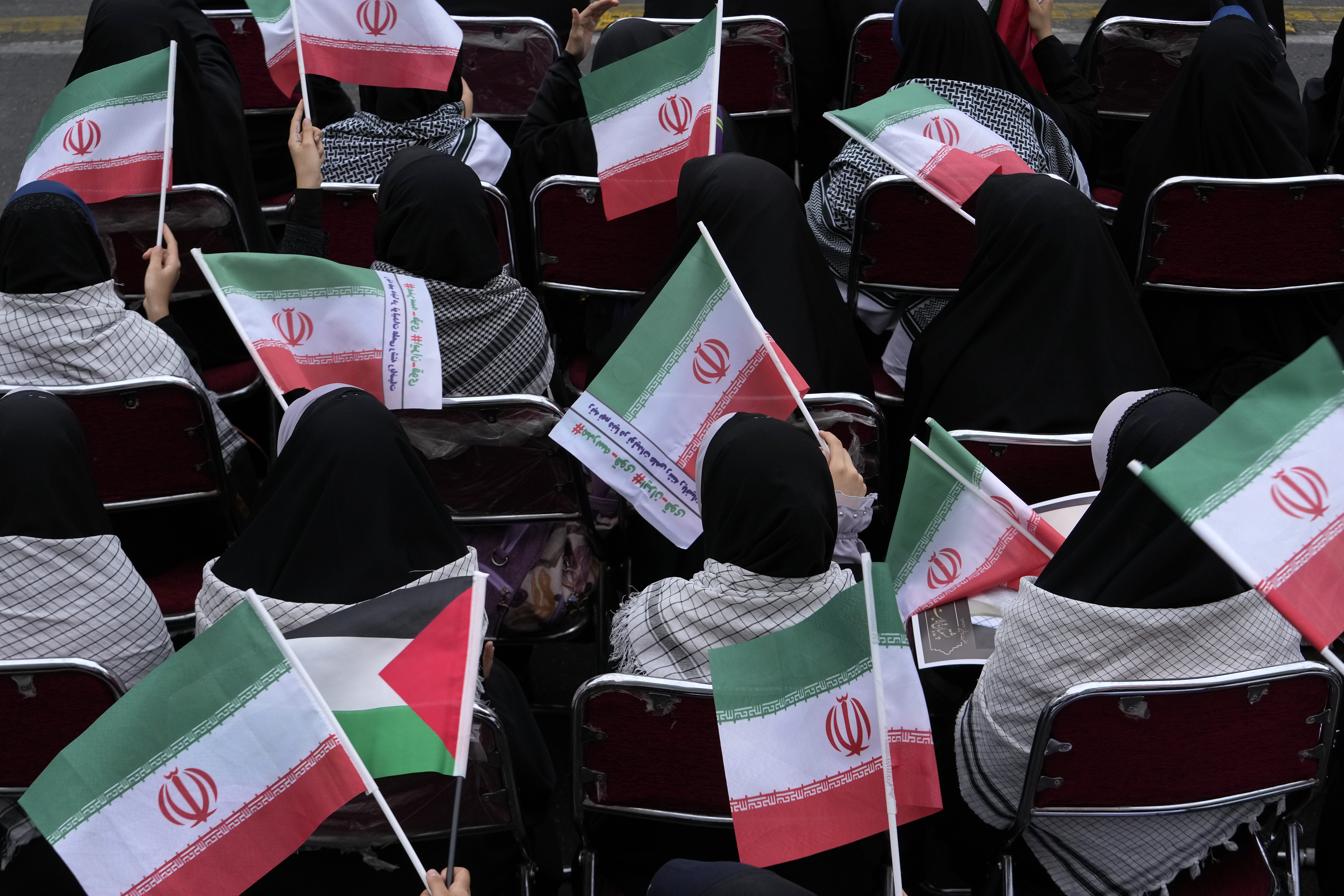 Demonstrators wave Iranian and Palestinian flags in an annual rally in front of the former U.S. Embassy in Tehran, Iran, Sunday, Nov. 3, 2024, marking the 45th anniversary of Iranian students' takeover of the embassy, starting a hostage crisis. (AP Photo/Vahid Salemi)