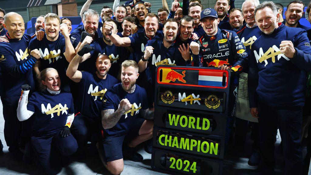 Max Verstappen and the Red Bull team celebrate his world title win with most people wearing t-shirts with 'Max' written across them and a '4' replacing the 'a'