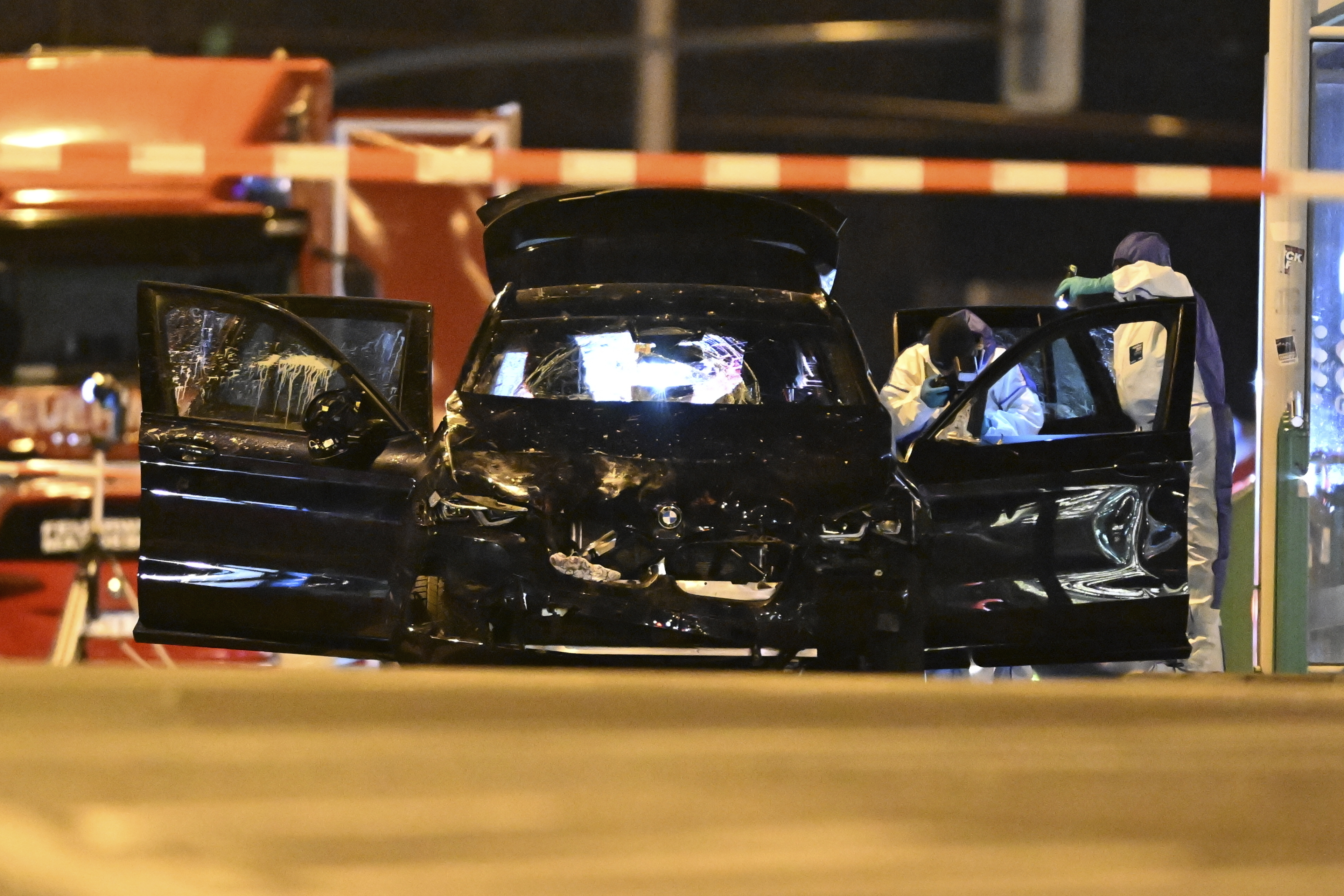 Forensics work on a damaged car sitting with its doors open after a driver plowed into a busy Christmas market in Magdeburg, Germany, early Saturday, Dec. 21, 2024. (Hendrik Schmidt/dpa via AP)