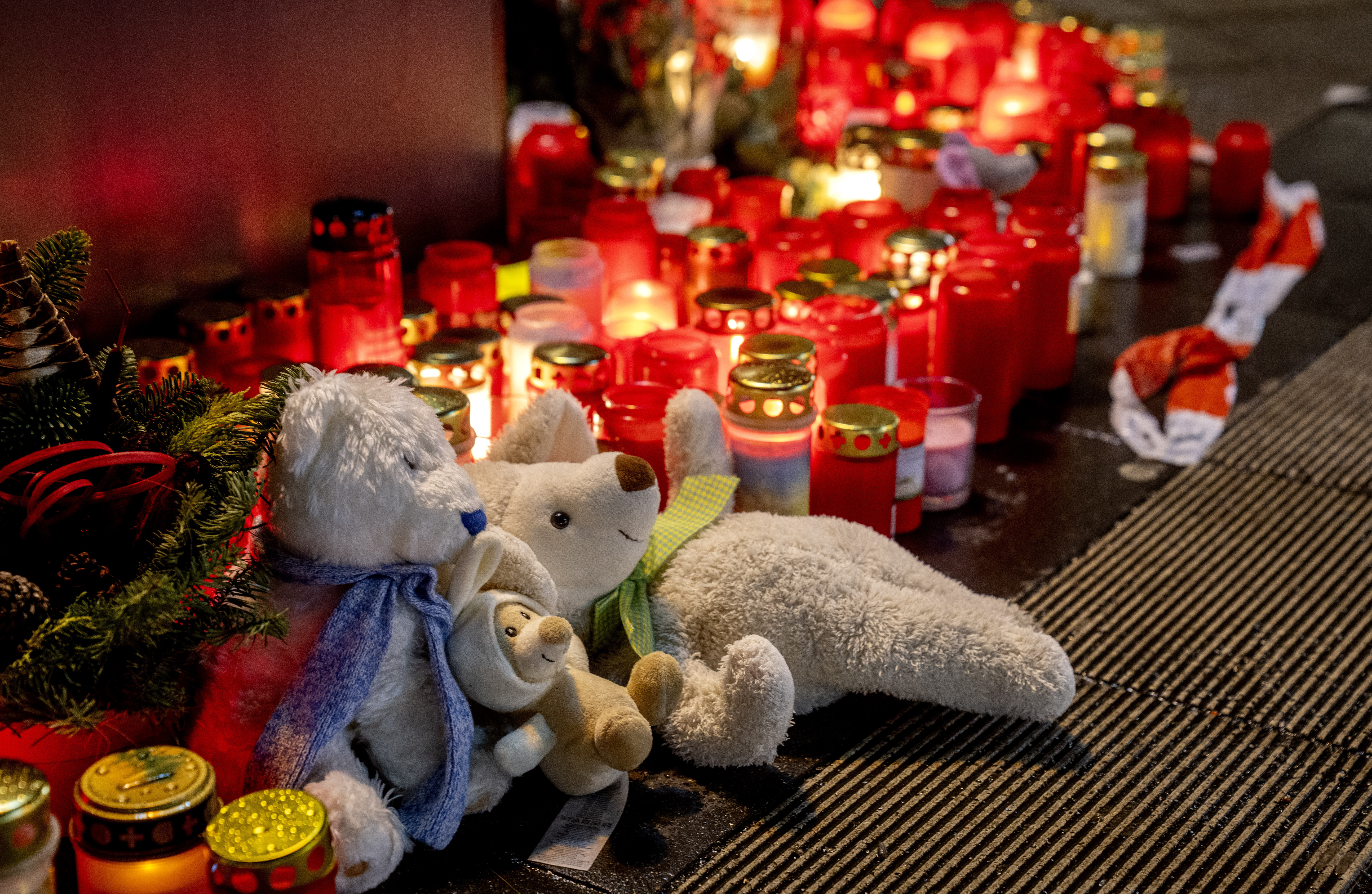 Teddy bears were laid together with candles near the Christmas market, where a car drove into a crowd on Friday evening, in Magdeburg, Germany, Sunday, Dec. 22, 2024. (AP Photo/Michael Probst)