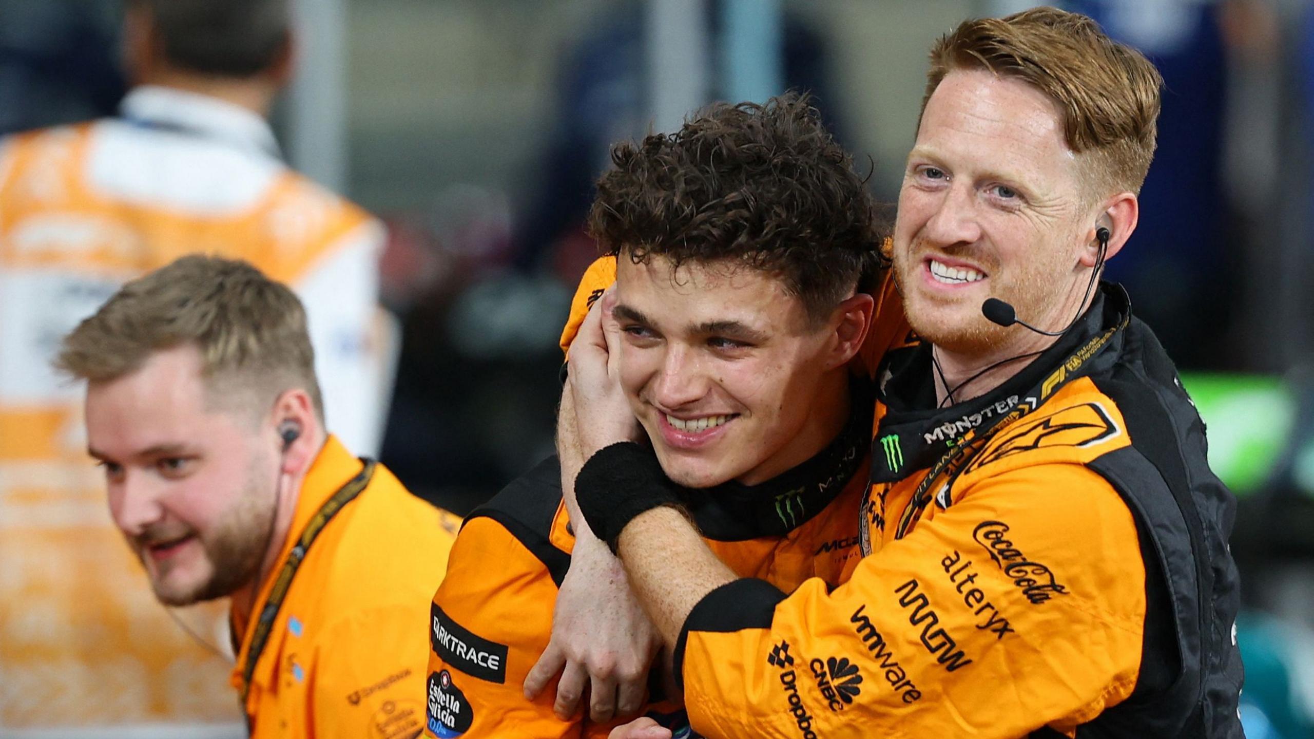 Lando Norris celebrates with a McLaren mechanic after winning the Abu Dhabi Grand Prix