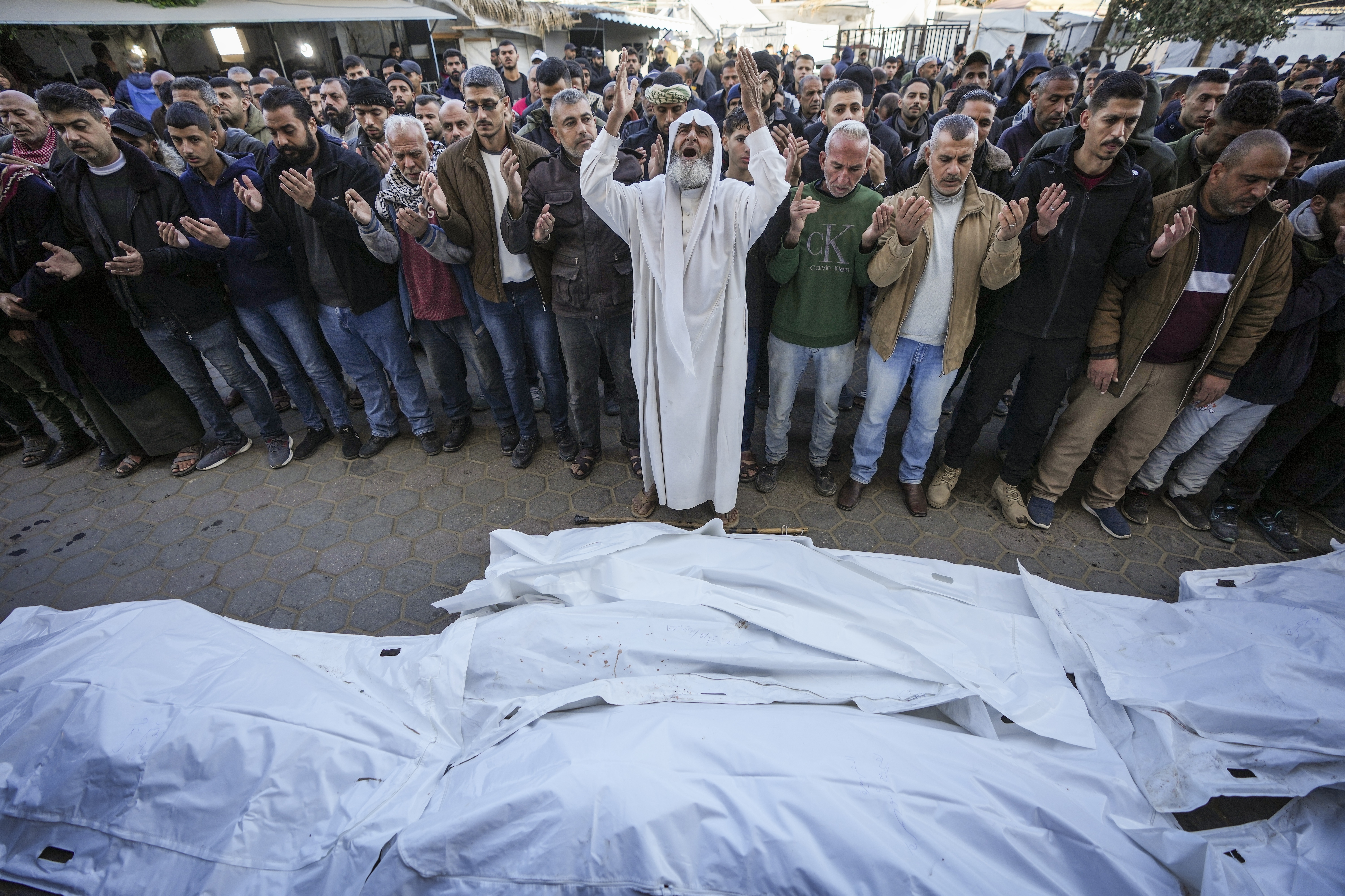 Palestinians pray over the bodies of the victims of an Israeli strike on a home late Saturday before the funeral outside the Al-Aqsa Martyrs Hospital in Deir al-Balah Sunday, Dec. 22, 2024. At least eight people were killed according to the hospital which received the bodies. (AP Photo/Abdel Kareem Hana)