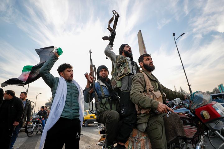 Syrian opposition fighters celebrate after the Syrian government collapsed in Damascus, Syria, Sunday, Dec. 8, 2024. (AP Photo/Omar Sanadiki)