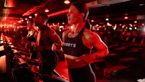 Tana von Zitzewitz Tana running on a treadmill in a sports bra, illuminated by red light.