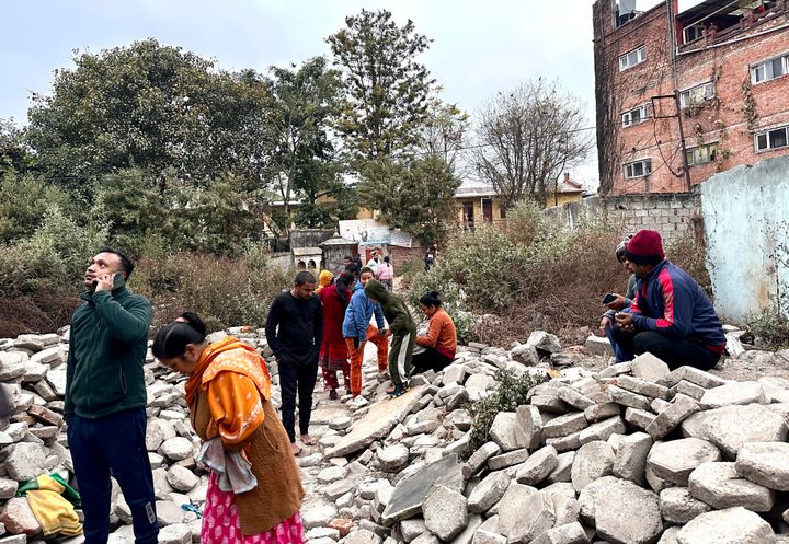 Nepalese people who rushed out of their homes after experiencing an earthquake stand amidst construction material in Kathmandu, Nepal, Tuesday, Jan.7, 2025. 