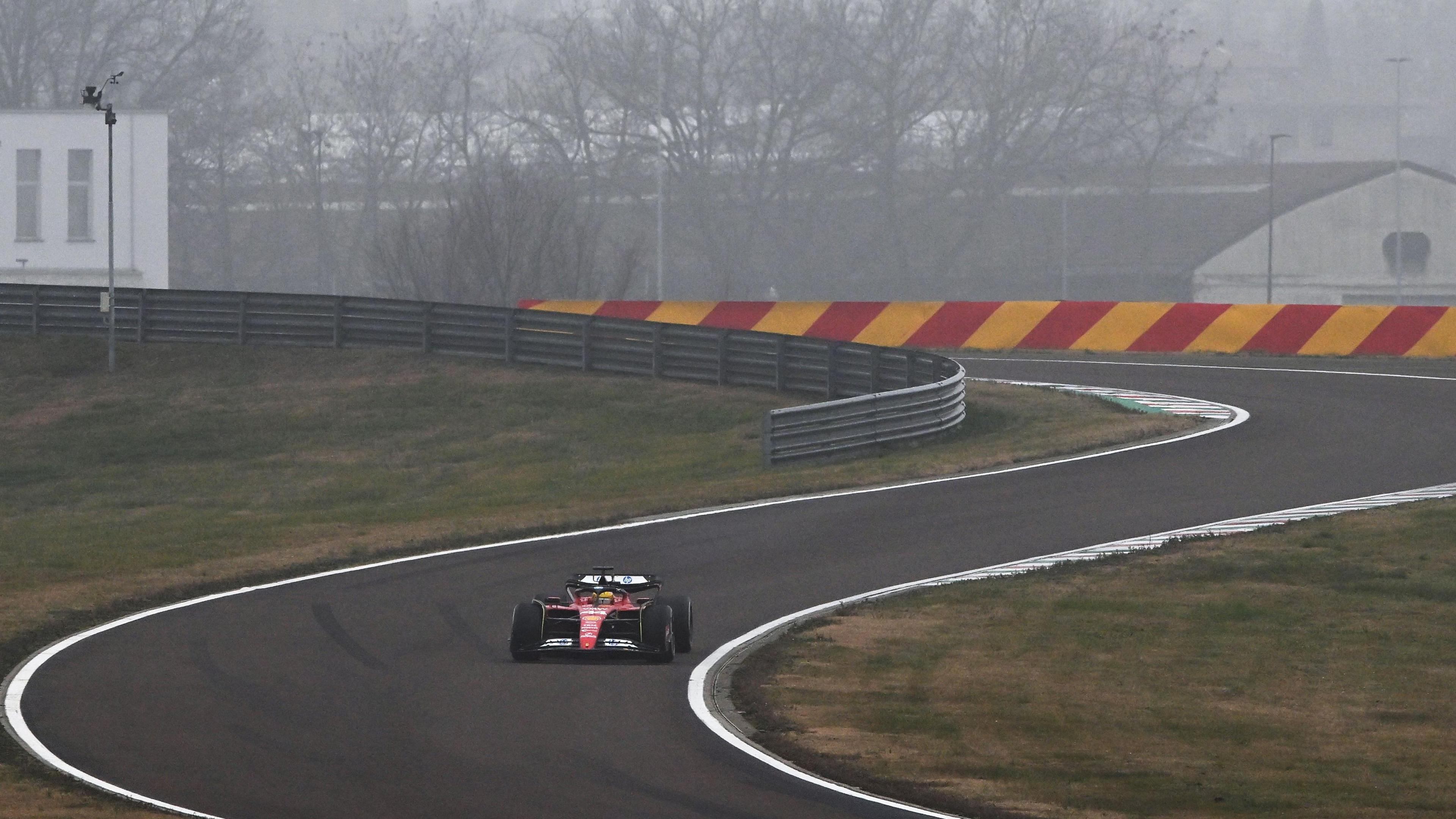 Lewis Hamilton is seen in a Ferrari against a foggy backdrop