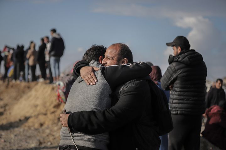 Displaced Palestinians embrace as hundreds of thousands walk along the Netzarim Corridor toward their homes in northern Gaza, during the ceasefire between Israel and Hamas, on Monday, Jan. 27, 2025.