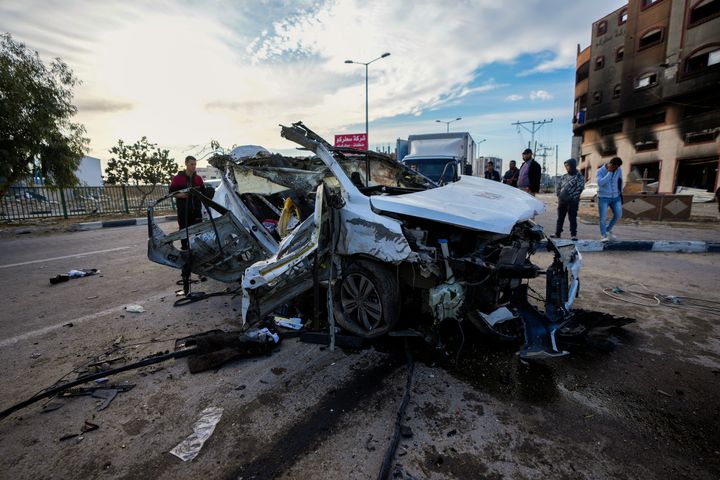 Palestinians inspect a car targeted in an overnight Israeli airstrike that killed its occupants in the town of Khan Younis, southern Gaza Strip, Saturday, Jan. 4, 2025. (AP Photo/Abdel Kareem Hana)