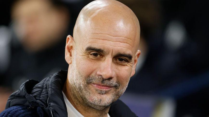 Manchester City manager Pep Guardiola smiles after reaching the Champions League play-offs with victory over Club Brugge