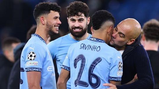 Manager Pep Guardiola plants a kiss on Savinho after his goal helped Manchester City into the Champions League play-offs with victory over Club Brugge