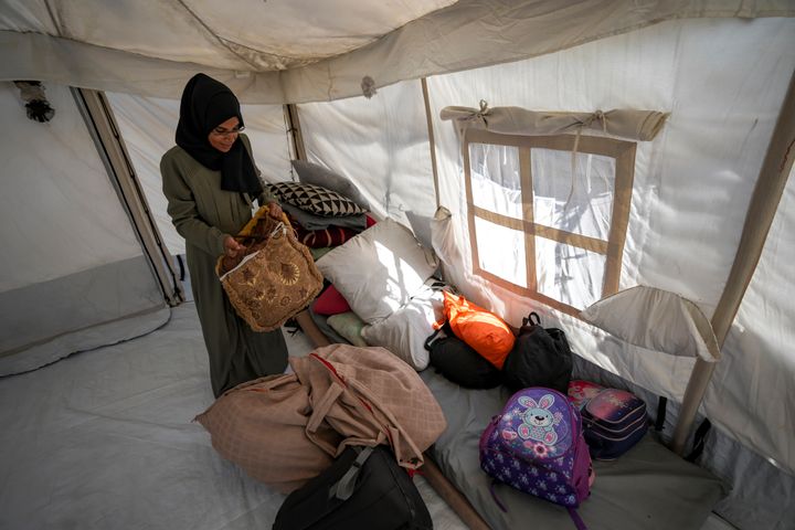 At a camp for displaced Palestinians in southern Gaza's Muwasi area, Majida Abu Jarad packs belongings as she prepares to go back to her family's home in the north, on Saturday, Jan. 18, 2025.