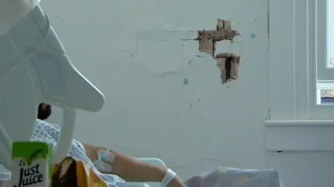 A hole in wall next to a patient in bed at St Mary's Hospital in London