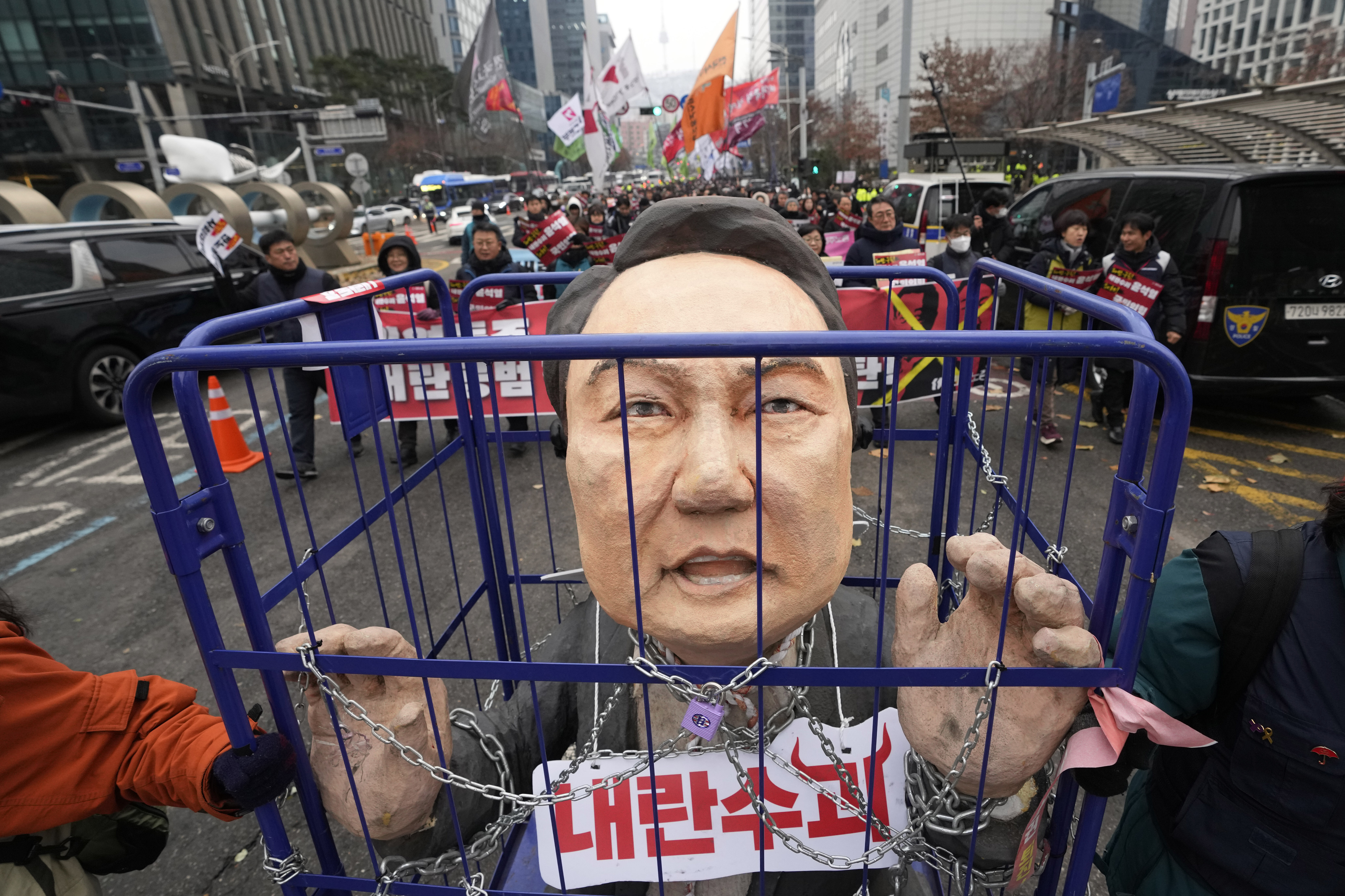 Protesters carry a caricature of impeached South Korean President Yoon Suk Yeol during a rally demanding his arrest in Seoul, South Korea, Saturday, Dec. 21, 2024. The sign, front, reads, "Rebellion leader."