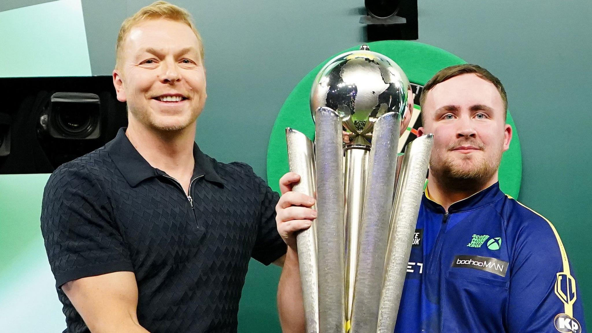 Sir Chris Hoy hands Luke Littler the Sid Waddell Trophy after winning the PDC World Darts Championship