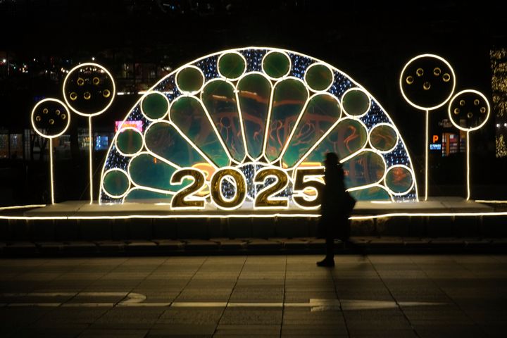 A woman walks near an illuminated decoration on New Year's Eve in Seoul, South Korea, Tuesday, Dec. 31, 2024. (AP Photo/Lee Jin-man)