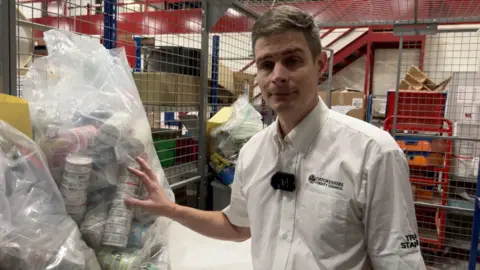 Jody Kerman from Oxfordshire Trading Standards standing next to a bag of confiscated nicotine pouches