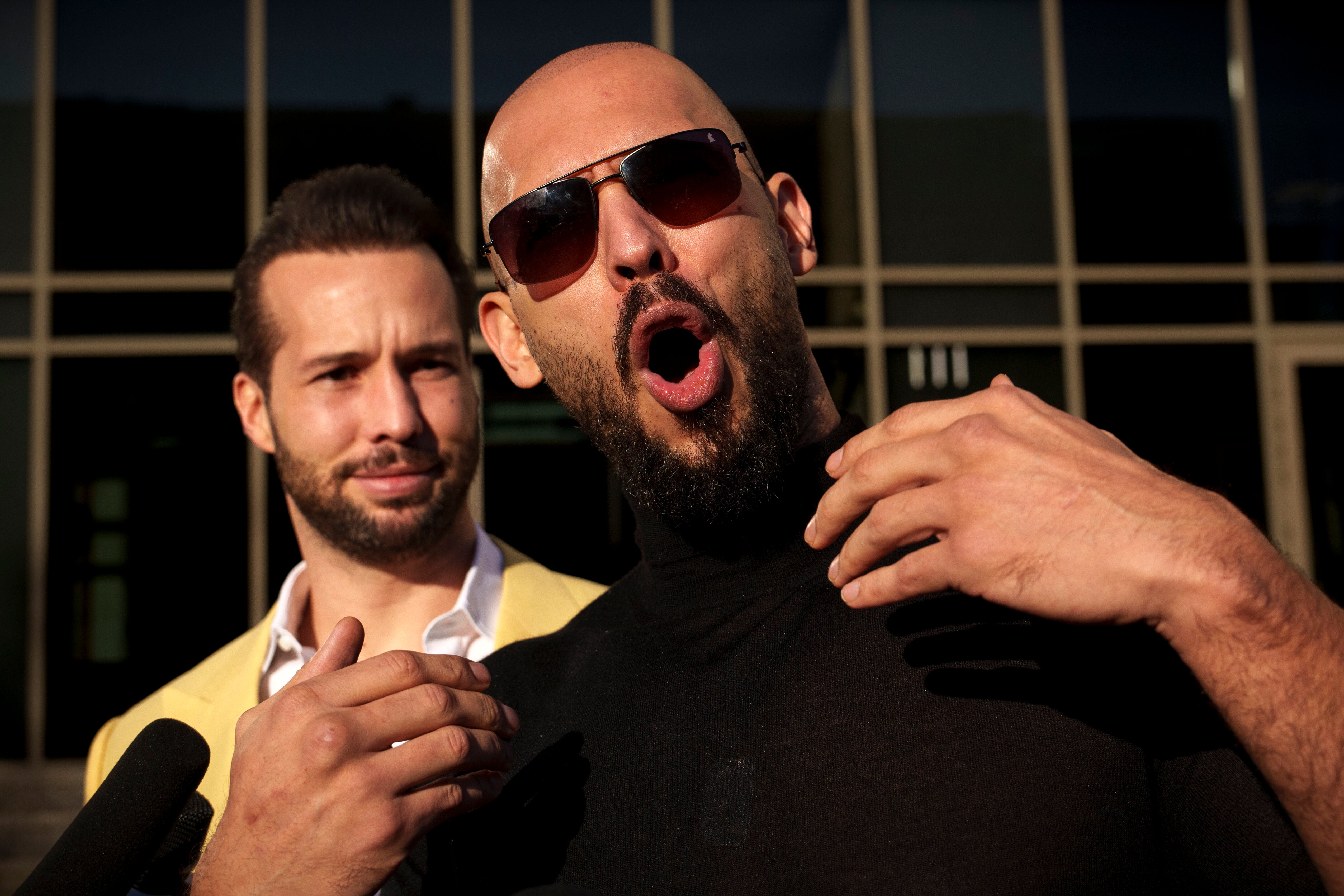 Andrew Tate gestures, next to his brother Tristan, outside the Bucharest Tribunal in Bucharest, Romania, on Jan. 9, 2025.