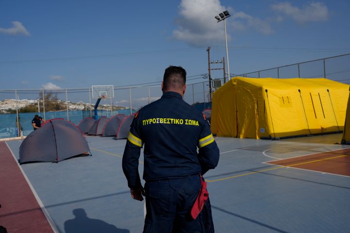 A firefighter walks next to tents set up at a basketball court to accommodate Fire Service rescuers as Greek authorities is taking emergency measures in response to intense seismic activity on the popular Aegean Sea holiday island of Santorini, southern Greece, on Feb. 3, 2025.