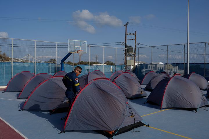 A firefighter walks among tents set up at a basketball court to accommodate Fire Service rescuers as Greek authorities are taking emergency measures in response to intense seismic activity on the popular Aegean Sea holiday island of Santorini, southern Greece, on Feb. 3, 2025.