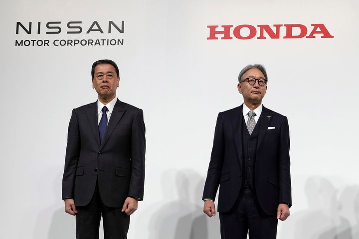 Nissan Chief Executive Makoto Uchida, left, Honda Chief Executive Toshihiro Mibe, right, pose for photographers during a joint news conference in Tokyo, Japan, on Dec. 23, 2024. (AP Photo/Eugene Hoshiko, File)