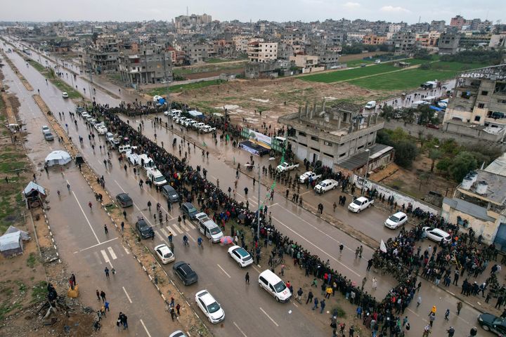 Palestinians gather as Hamas fighters deploy ahead of the planned release of Israeli hostages set to be handed over to the Red Cross in Nuseirat, central Gaza Strip, Saturday, Feb. 22, 2025. (AP Photo/Mohammad Abu Samra)