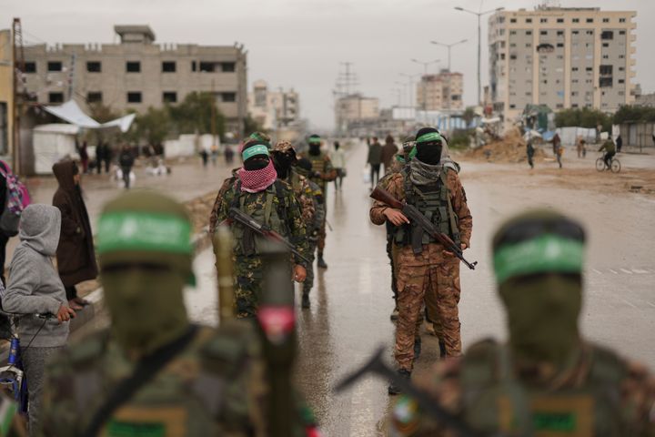 Hamas fighters take position ahead of the planned release of Israeli hostages set to be handed over to the Red Cross in Nuserait, Gaza Strip, Saturday, Feb. 22, 2025. (AP Photo/Abdel Kareem Hana)