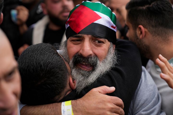 A Palestinian prisoner wearing a Palestinian flag headband is greeted as he exits a Red Cross bus after being released from Israeli prison following a ceasefire agreement between Israel and Hamas, in the West Bank city of Ramallah, Saturday, Feb. 1, 2025. (AP Photo/Nasser Nasser)