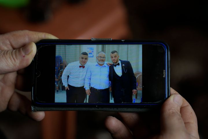 Mohammed Shula shows a picture on his phone of him and his sons, Bilal and Yazan, inside a relative's house where he and his wife have taken refuge in the West Bank village of Kafr al-Labad, on Monday, Feb. 10, 2025.