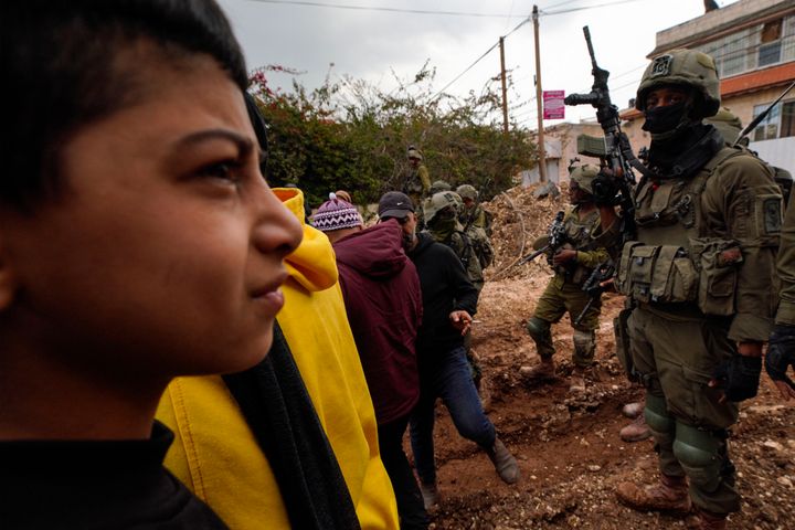 Israeli soldiers block a road preventing Palestinians from accessing the Jenin refugee camp during an ongoing military operation, on Feb. 19, 2025.