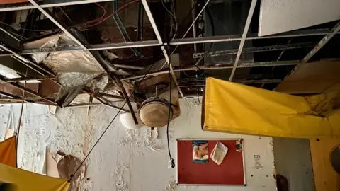 An abandoned pain clinic is pictured with a caved in wall