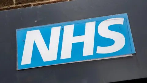 Getty Images The blue and white NHS logo. 