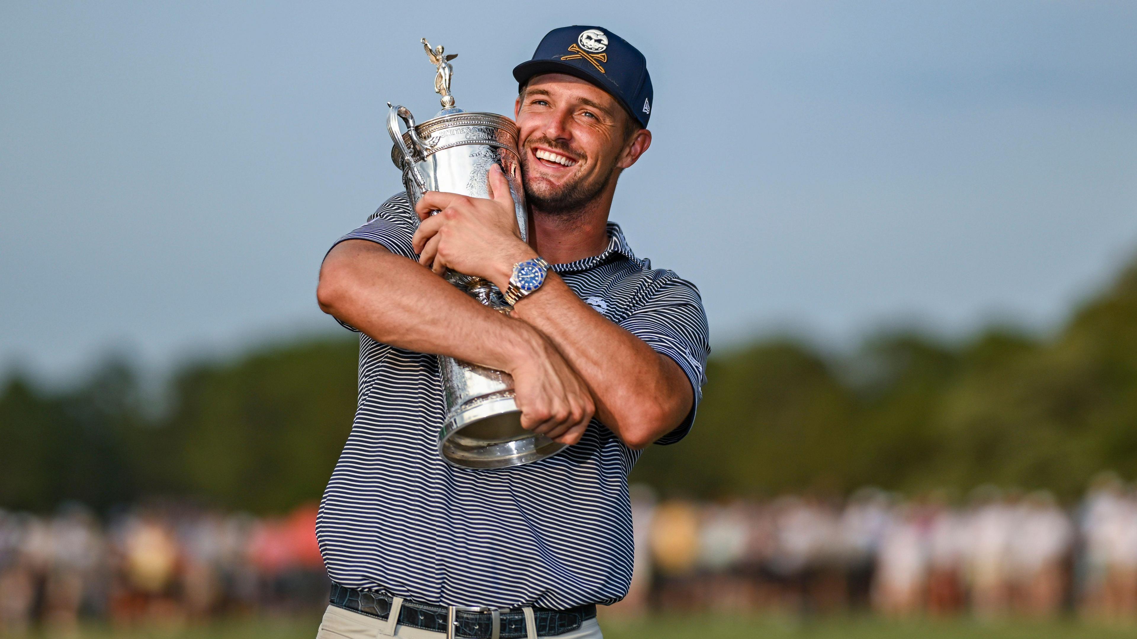 Bryson DeChambeau holds up the 2024 US Open trophy 